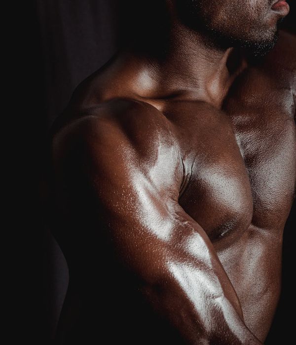 A focused man performing a bodyweight strength exercise in a dark gym.