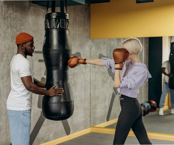 A trainer providing guidance to a man during an exercise session.